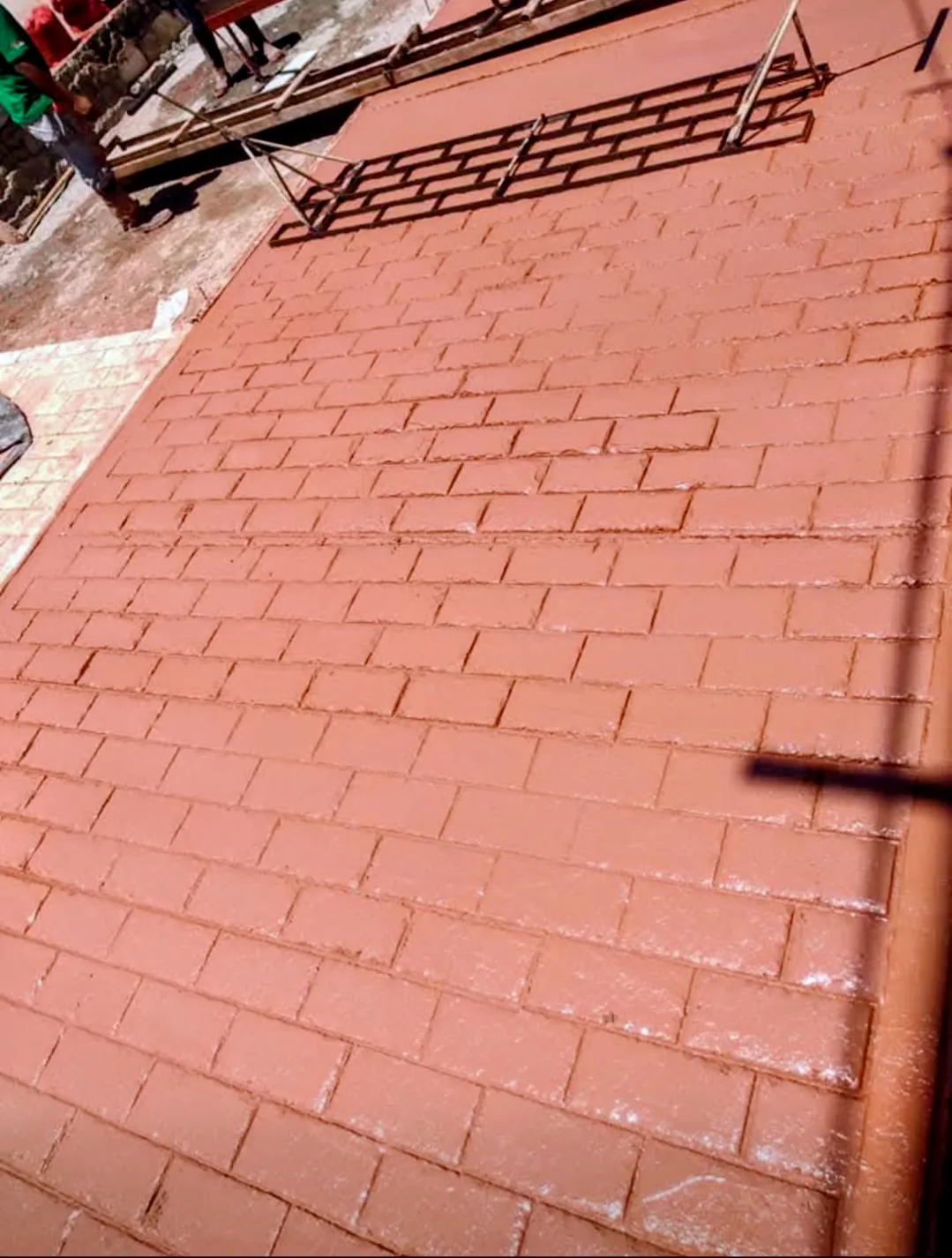 Concreto artesanal con un acabado en simulación de tabique y color óxido